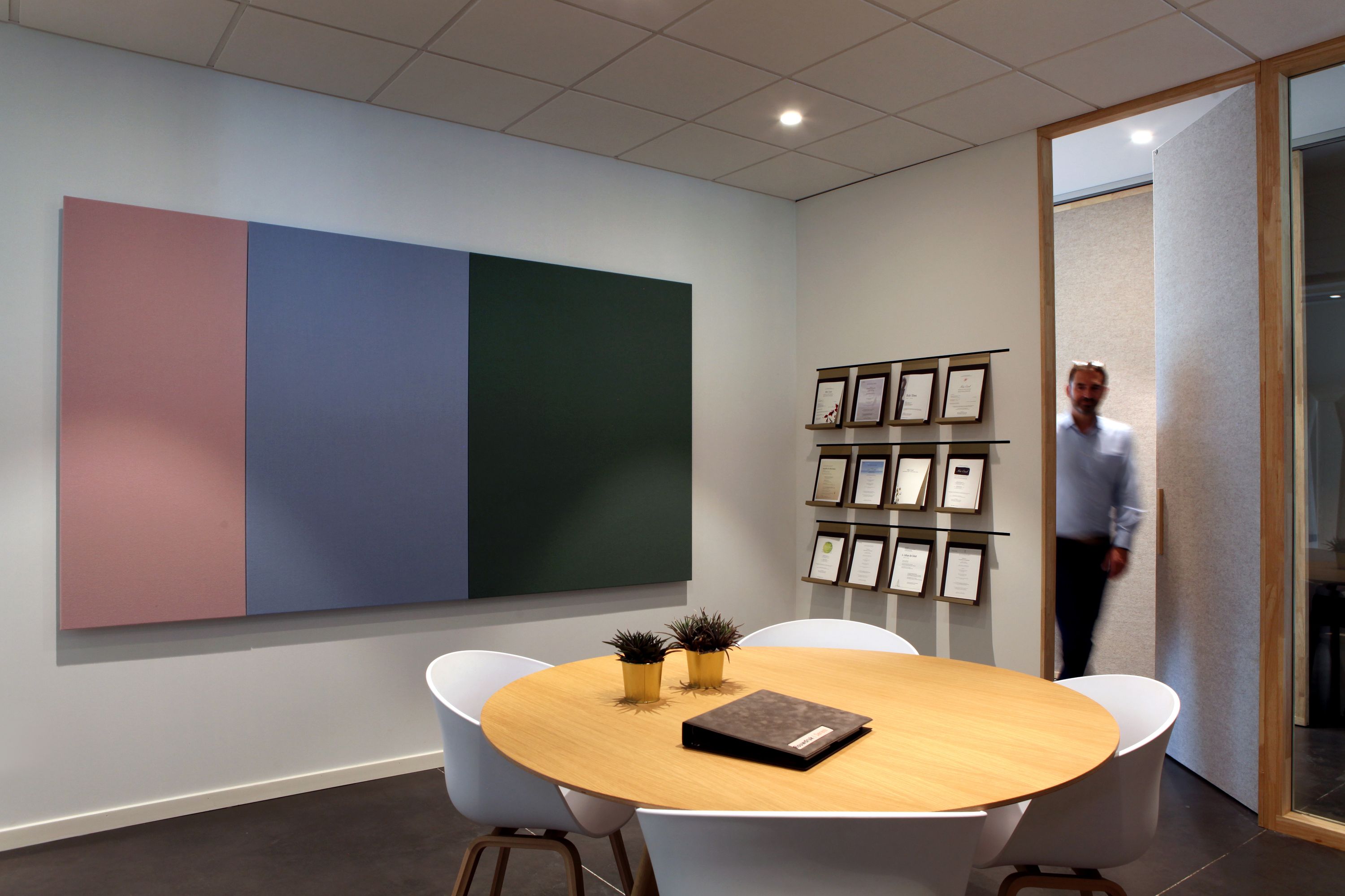 Van Kuyk Uitvaartcentrum Antwerpen — zitruimte met kunstwerk en ronde tafel